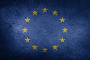 Bandiera dell'Unione Europea rovinata, copertina della segnalazione di una call della conferenza 2023 di ESPAnet Italia sull'Europa Sociale in un contesto di crisi multiple: sfide, opportunità e prospettive